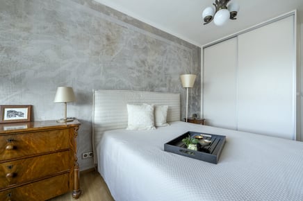 Světlá ložnice s postelí, komodou a šatní skříní v moderním stylu. obrazová tapeta